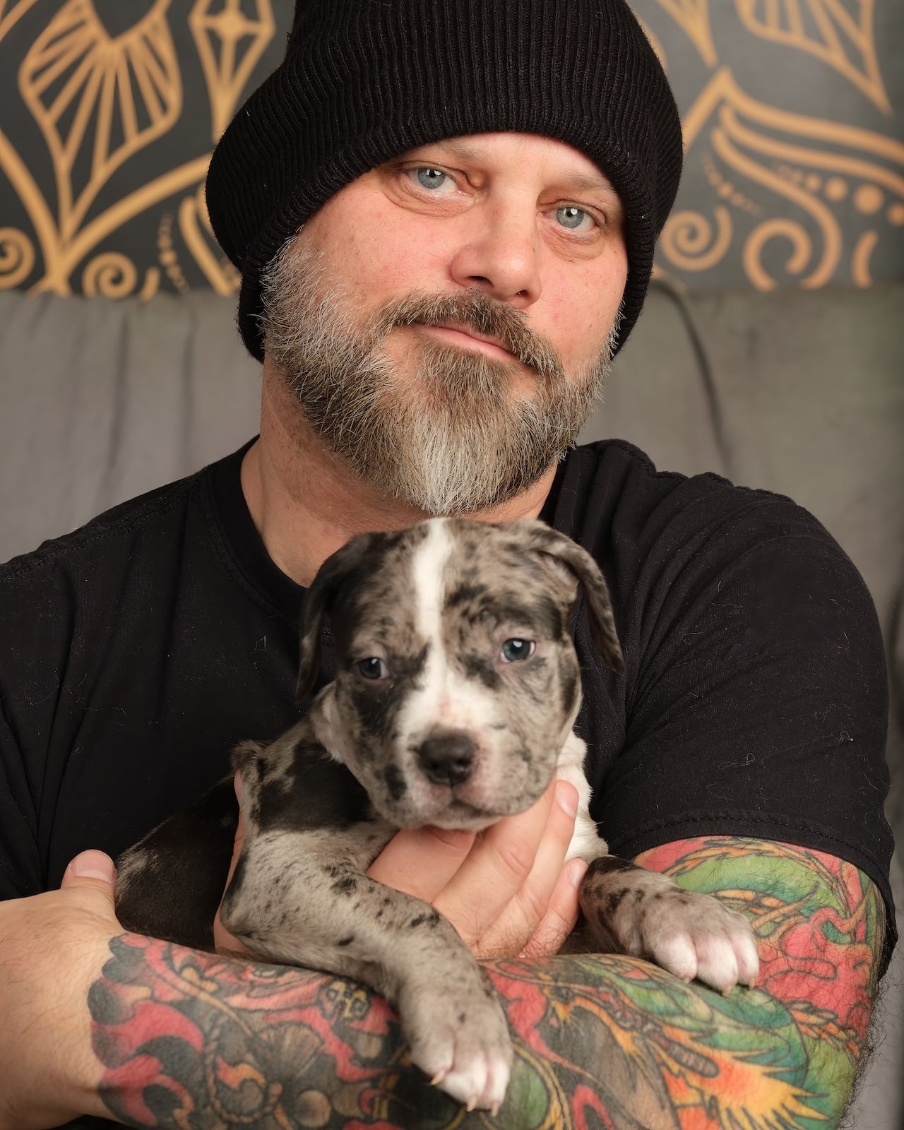 South of Heaven Tattoo artist Sean holding a puppy